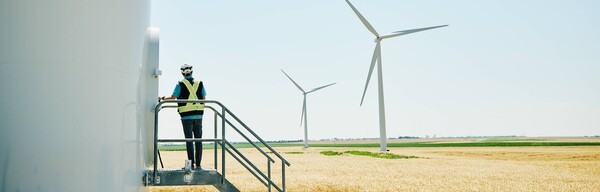 Person standing and looking at windmills.