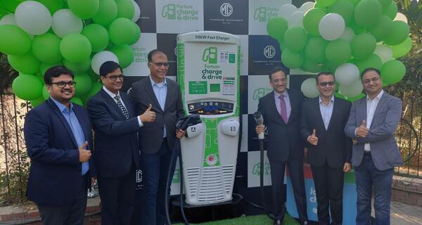 Six men at a Fortum and MG EV charging station opening in India