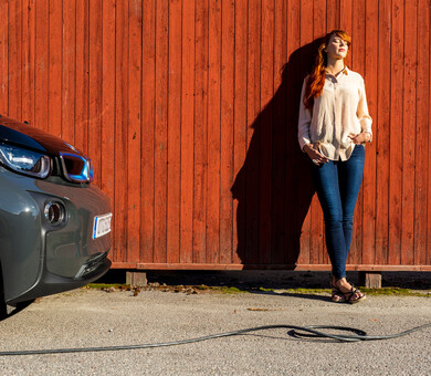 Woman charging electric car in the sun